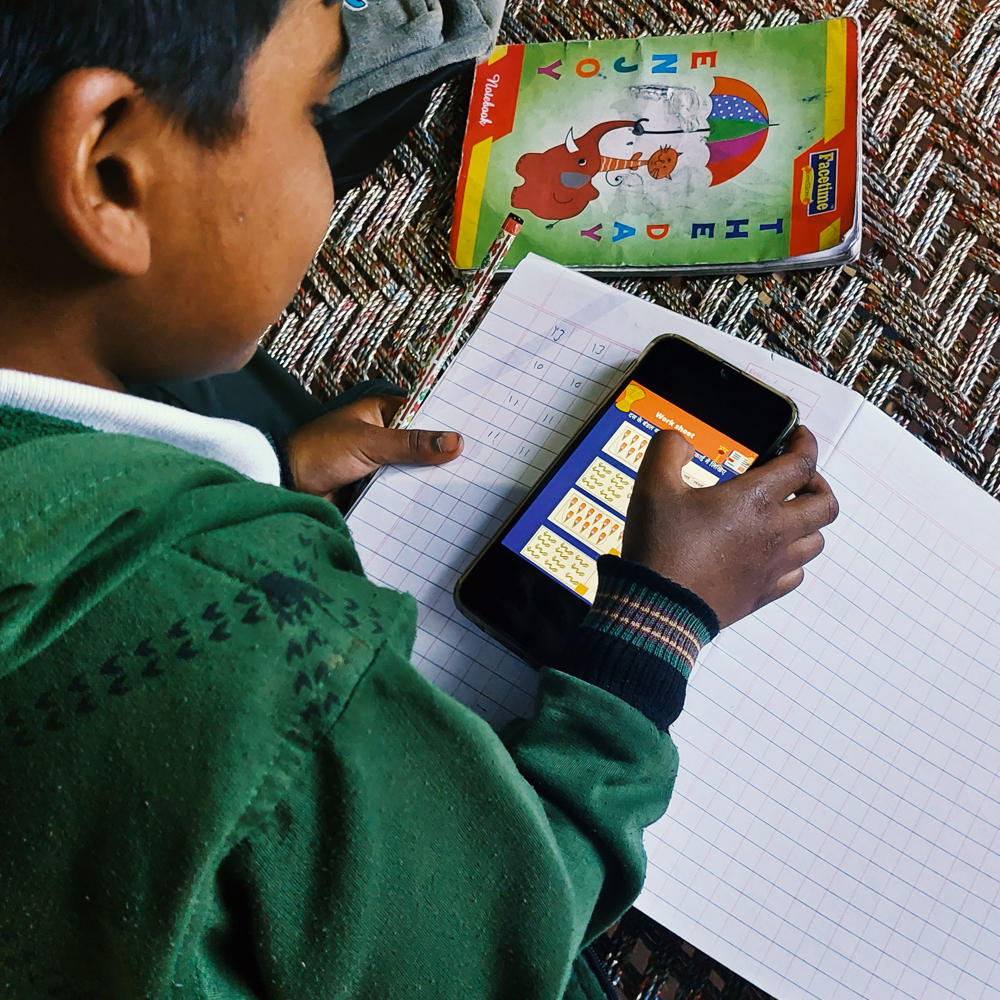 Woman teaching children in India using a phone