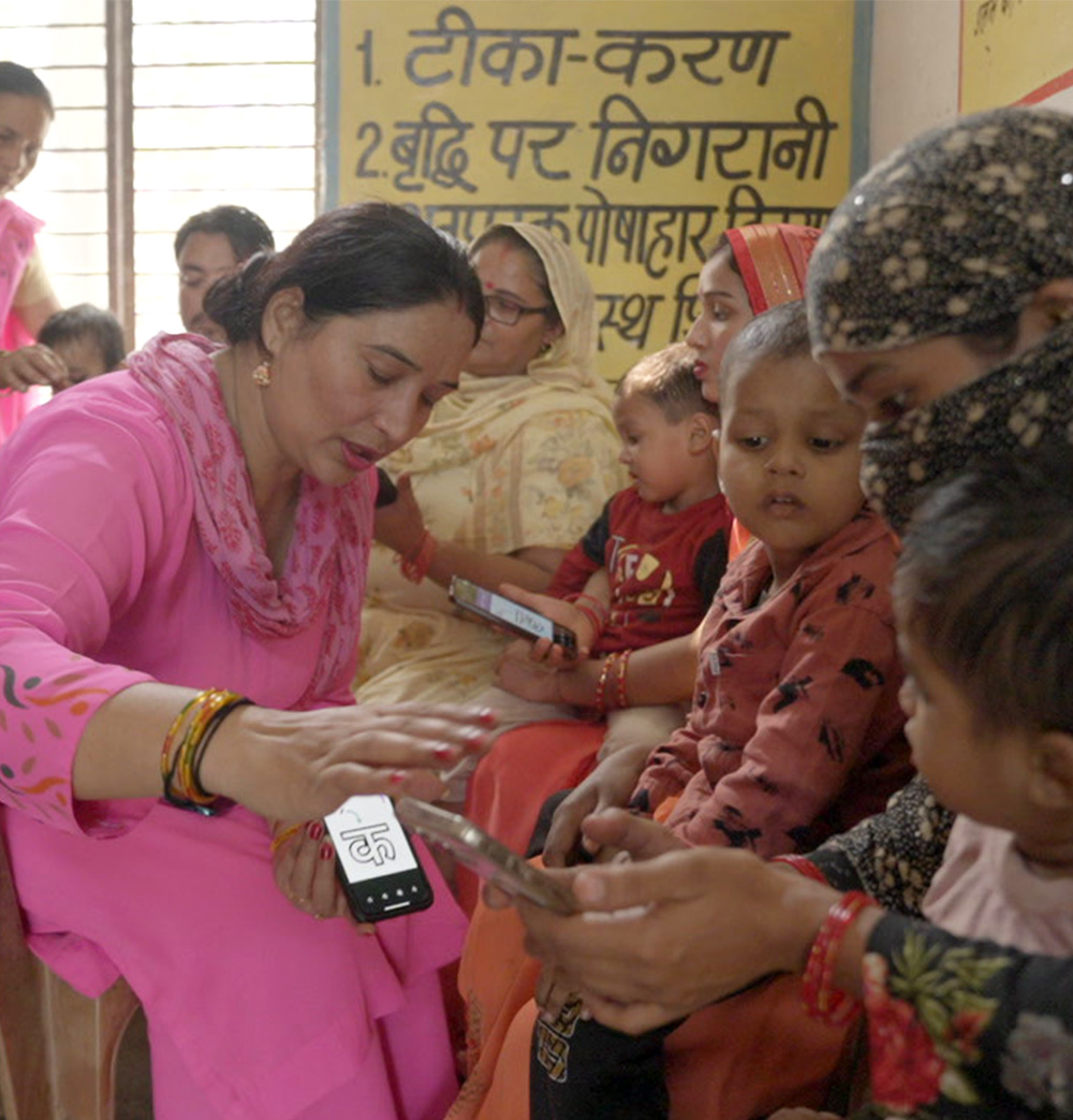 Woman teaching children in India using a phone