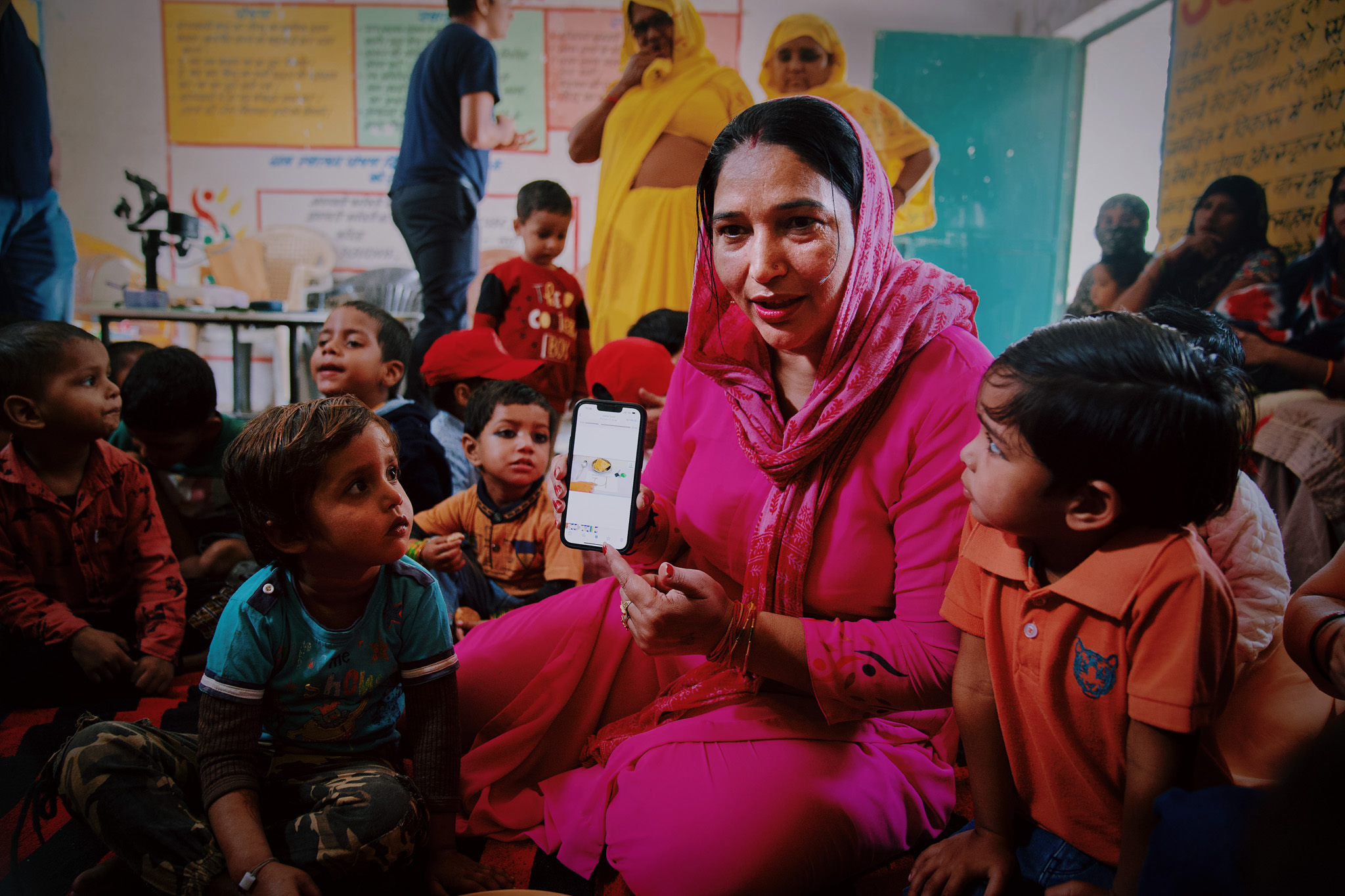 I woman teaching kids on a phone in India