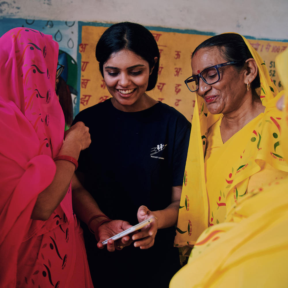 Woman teaching children in India using a phone