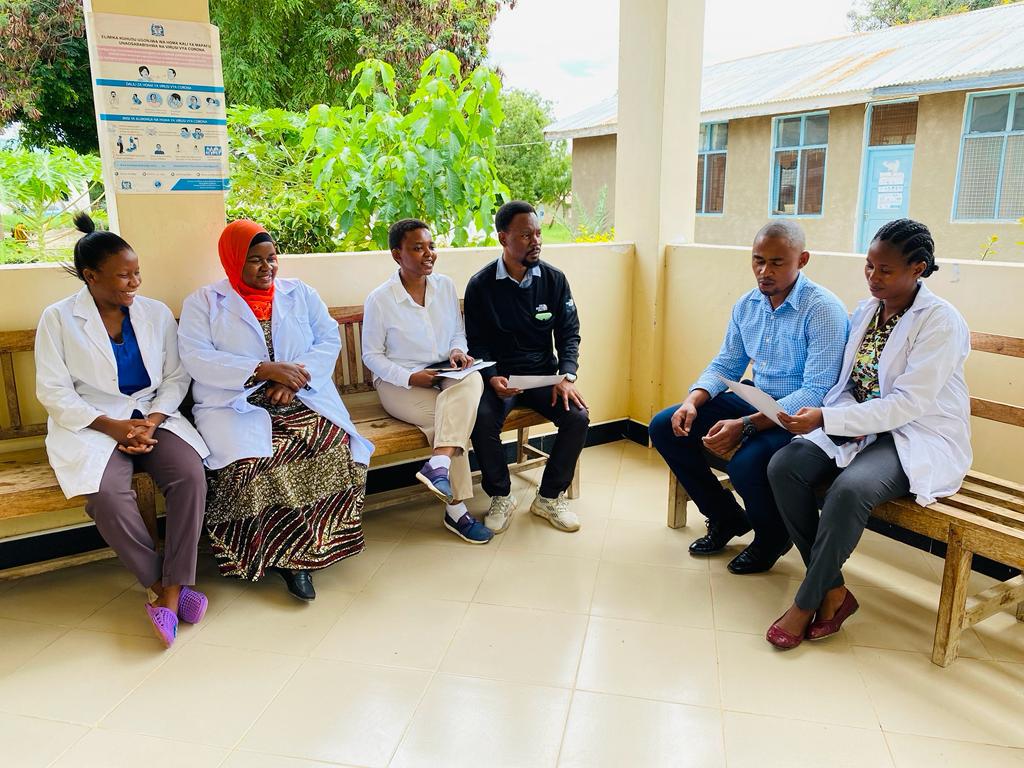 Health workers seated with advocates at a health centre in Tanzania 